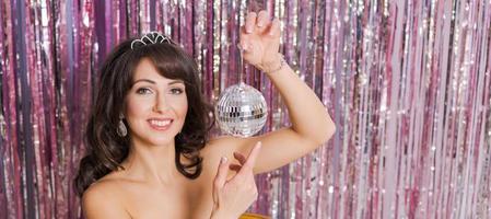 Women holding Christmas shining ball on festive background with branches photo