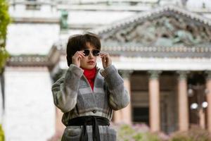 Portrait of a young woman in sunglasses in a coat against the background of Cathedral photo