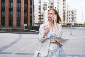 Overworked business woman. Business woman multitasking while talking on photo