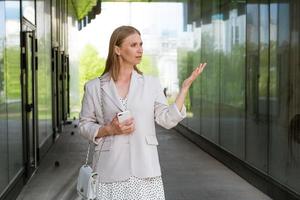 Smiling woman in casual clothes standing by the office. Business woman photo