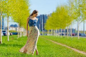 Portrait happy beautiful young woman relaxing in park in long dress. Joyful photo