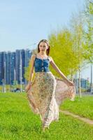 Attractive happy young woman long flowered dress flying her hair enjoying free photo