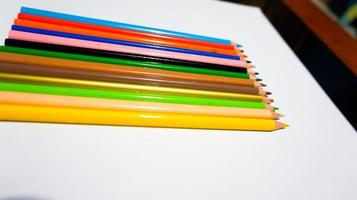 Wooden color pencils arranged in bulk on a white isolated background photo