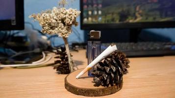 Cigarette and gas lighter on wooden photo