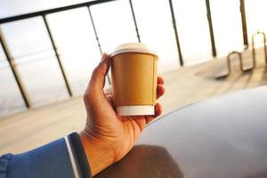 men holding a take away paper coffee cup photo