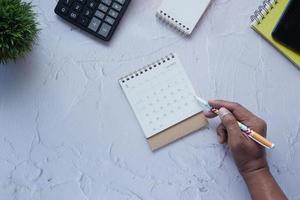 deadline concept with hand marking date on calendar top view photo