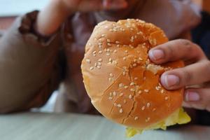 hand holding beef burger on table close up photo