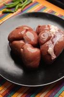 Raw fresh lamb kidneys on a chopping board photo