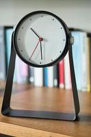 simple modern clock on a book shelf . photo