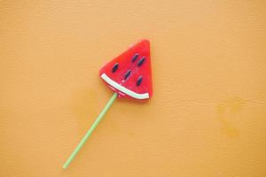 Top view of colorful lollipop on orange background, photo