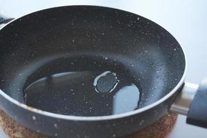 detail shot of Pouring vegetable oil into frying pan. photo