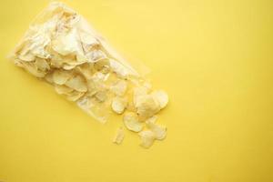 potato chips spilling form a packet on table photo