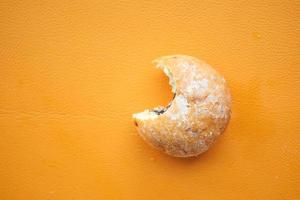 half eaten donuts on a orange color background photo