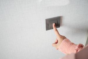 A finger turning on lighting switch . photo