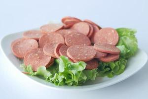 Slices of salami on white background. photo