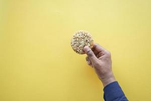 overhead view of holding a sweet cookies on yellow background photo