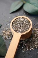 close up of chia seed in a wooden spoon on table photo