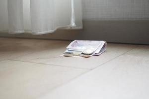 left cash and coins on floor at home photo