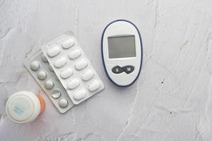 diabetic measurement tools and medical pills on table photo