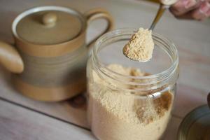 spoon pick brown sugar from a container photo