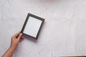 top view of empty frame on wooden background . photo