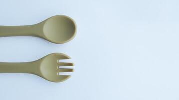 Brown silicone fork and spoon baby utensil isolated on white and some negative space. photo