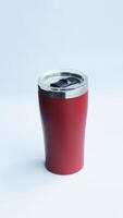 Red stainless steel tumbler and mug vacuum insulated double wall travel cup with lid isolated on white. photo