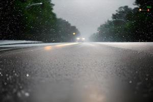 pesado lluvia soltar a medio de el la carretera superficie bokeh antecedentes. foto