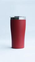 Red stainless steel tumbler and mug vacuum insulated double wall travel cup with lid isolated on white. photo