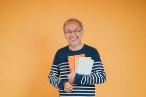 contento positivo mayor masculino sonriente y leer libro educación conocimiento aprendizaje en color antecedentes. foto