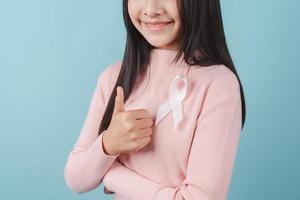 happy woman showing pink ribbon, Breast cancer awareness, world cancer day, national cancer survivor day in february concept. photo