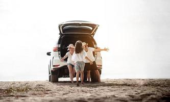 familia viaje coche la carretera viaje concepto. verano vacaciones en coche en el atardecer, papá, mamá y hija contento de viaje disfrutar y relajación juntos conducción en vacaciones, gente,estilo de vida con transporte foto