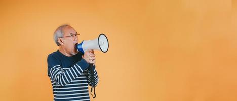 Senior male shouting with megaphone for announce news or discount sale shopping on color background. photo
