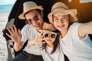 Happy asian family on the beach in holiday. of the family take a selfie.They are having fun playing enjoying on the beach. Summer Family and lifestyle. photo