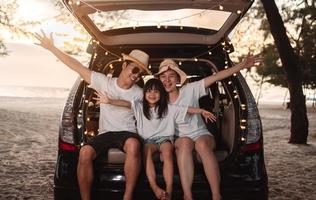 Happy Family with car travel and camping road trip. summer vacation in car in the sunset, Dad, mom and daughter happy traveling enjoy together driving in holidays, people lifestyle ride by automobile. photo