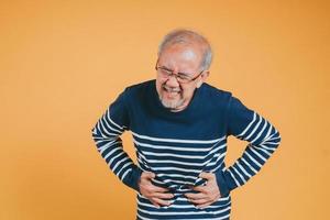 asiático mayor hombre sensación Dolor de estómago. más viejo maduro masculino toque barriga. intestino problema salud cuidado y médico seguro concepto. foto