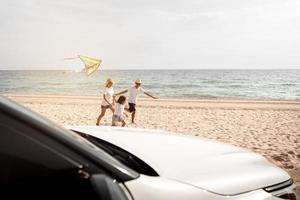 familia feliz con viaje en coche viaje por carretera. vacaciones de verano en automóvil al atardecer, papá, mamá e hija felices viajando disfrutan juntos conduciendo en vacaciones, el estilo de vida de la gente viaja en automóvil. foto