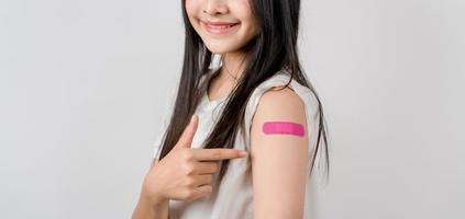 Young woman after getting a vaccine. showing shoulder arm with bandage after receiving vaccination, herd immunity, side effect, booster dose, vaccine passport and Coronavirus pandemic photo