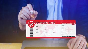 Hand holding boarding pass tickets air travel concept, Choosing checking electronic flight ticket on laptop. photo