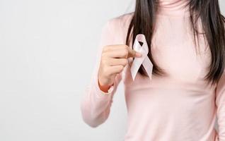 woman hands holding pink ribbon, Breast cancer awareness, world cancer day, national cancer survivor day in february concept. photo