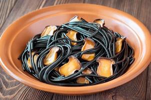 Black pasta with mushrooms photo