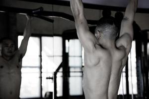 Sexy body of muscular young soldier Asian man in gym. Concept of health care, exercise fitness, Strong muscle mass, body enhancement, fat reduction for men's health supplement product presentation. photo