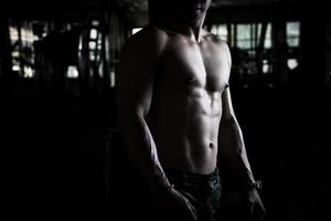 Sexy body of muscular young Asian man in gym. Concept of health care, exercise fitness, Strong muscle mass, body enhancement, fat reduction for men's health supplement product presentation. photo