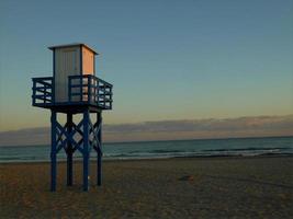 torre de vigilancia a puesta de sol en el apuntalar de el playa. foto