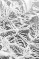 Fantastic pattern of unusual texture of white melted polyethylene on gray background. Vertical shot. photo