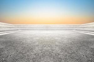 A concrete floor with a blue sky and the sun is setting photo