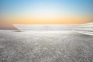 A concrete floor with a blue sky and the sun is setting photo