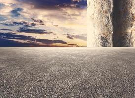A wall with a large column and a sunset in the background photo