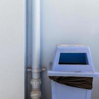 The blue plastic bin next to the blue building wall is the same tone. photo