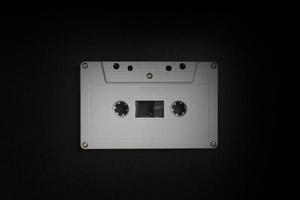 Retro old cassette tapes arranged on a dark wooden background in the dark with studio lighting. photo